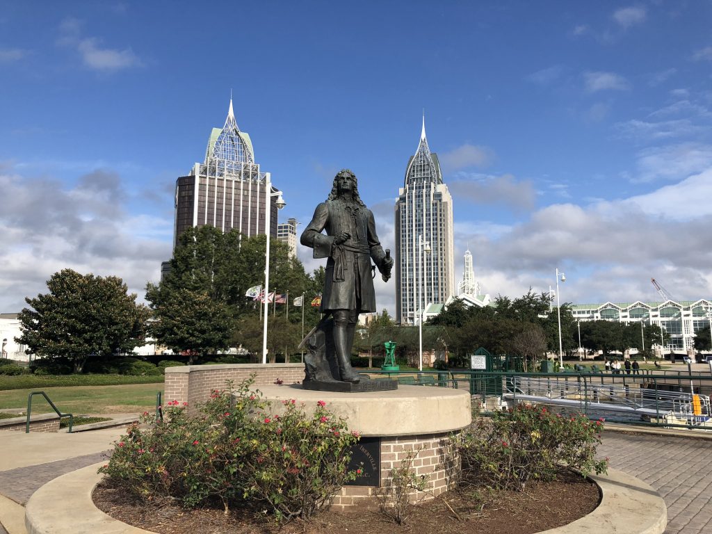 Statue of Pierre Le Moyne d'Iberville in front of Mobile's skyline